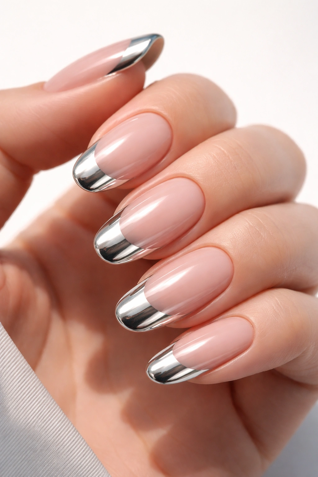 Close-up of long nails with chrome tips reflecting light