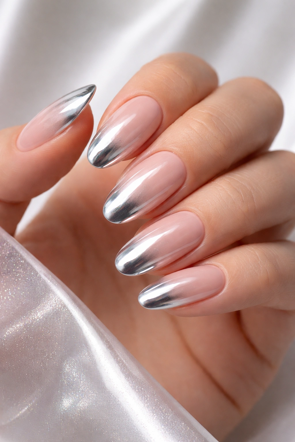 Close-up of chrome-coated French tips on nude nails.