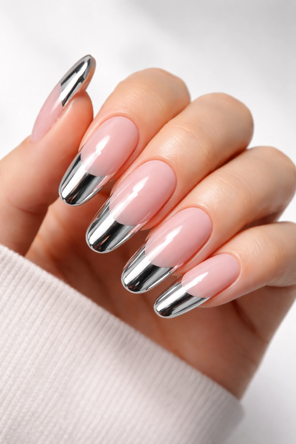 Bold chrome metallic tips on long round nails reflecting light.