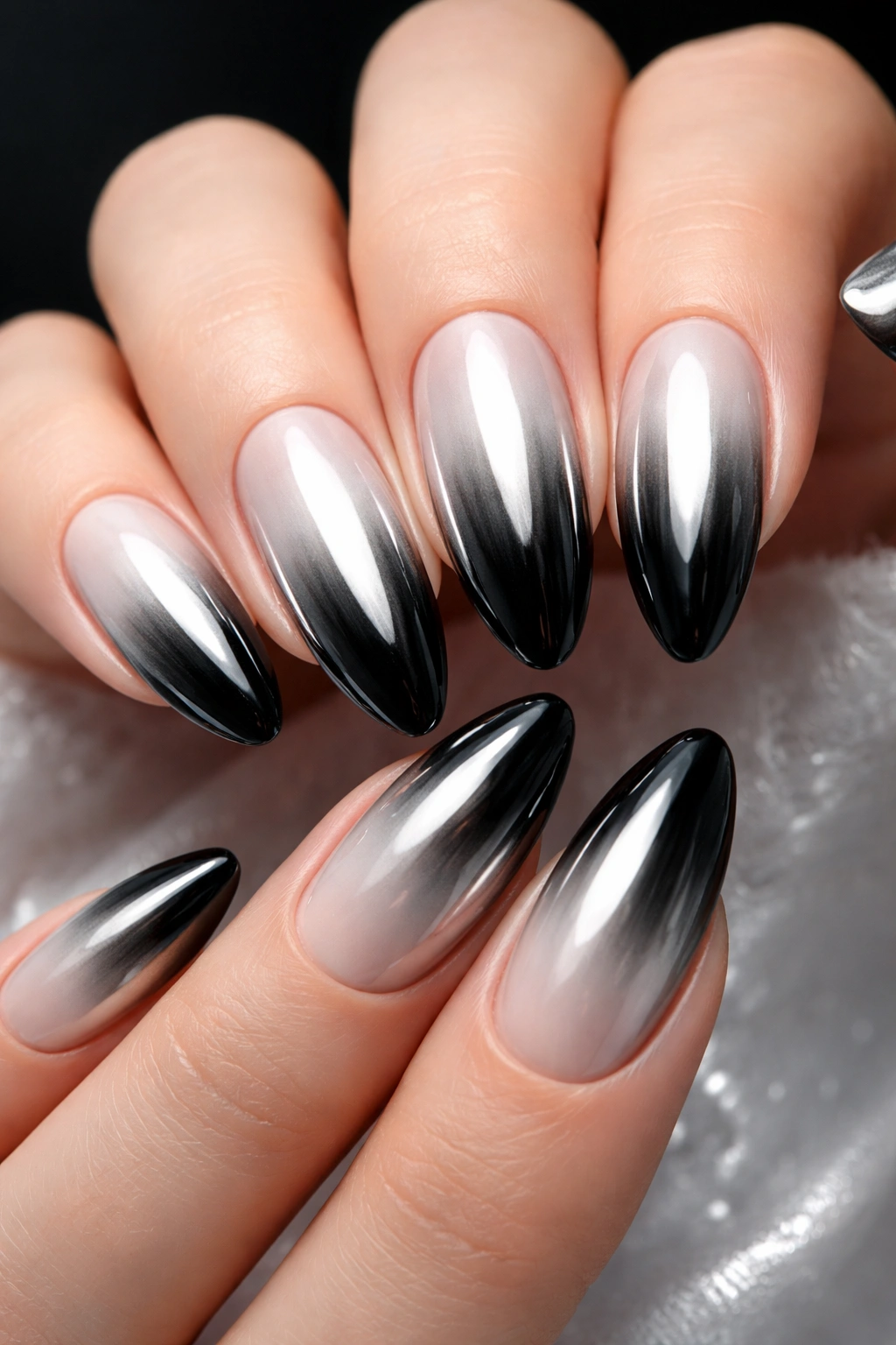 Close-up of black to white chrome ombré nails with high-gloss reflective finish