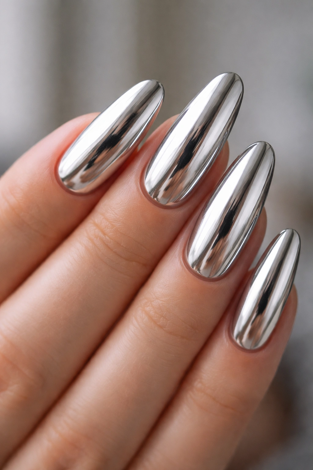 Close-up of chrome long oval nails with mirror finish
