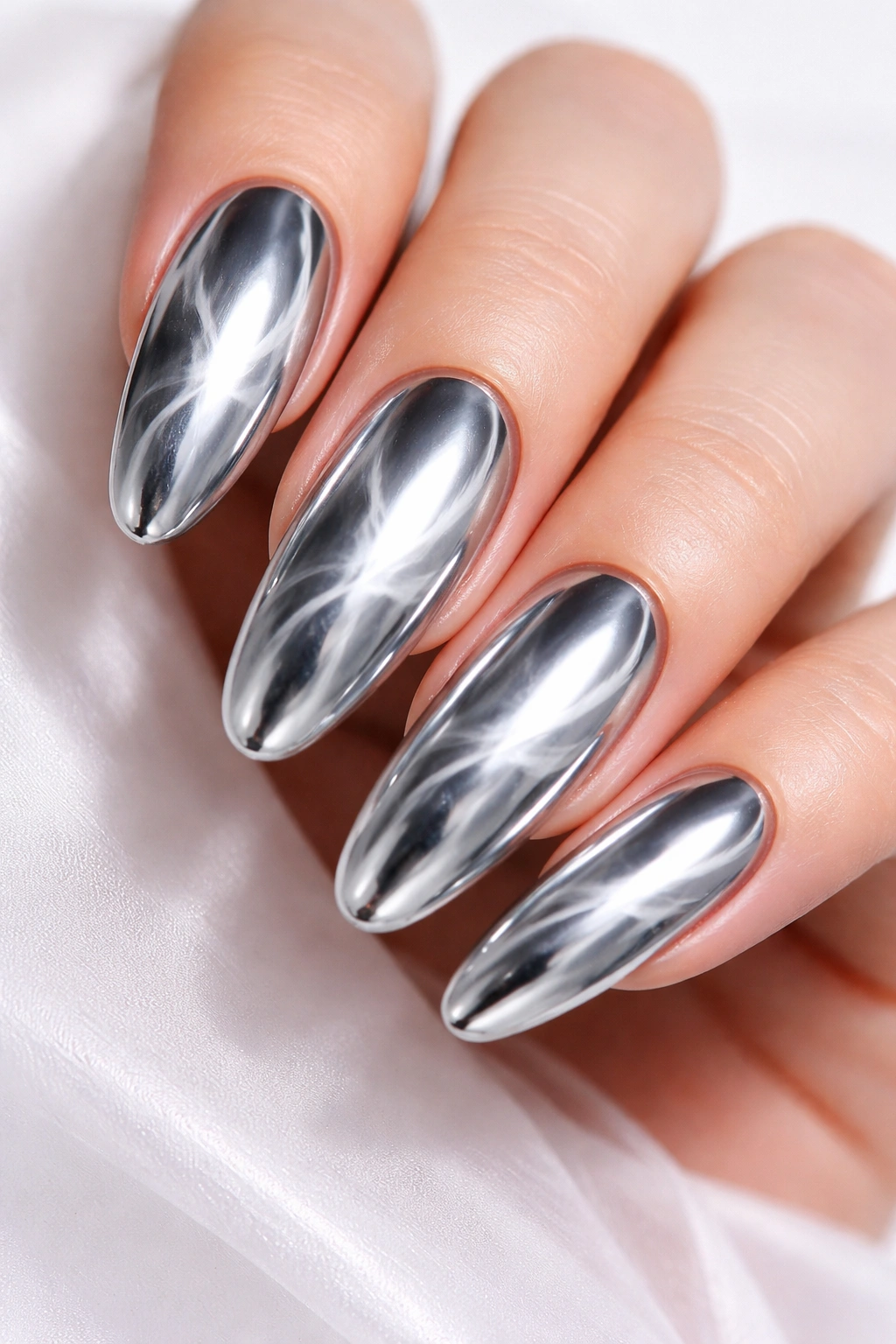 Close up of extra-long oval nails with chrome mirror finish and smoke swirl