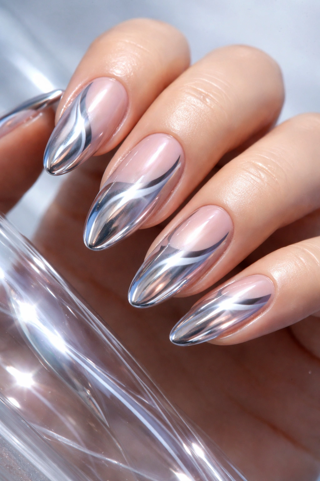 Close-up of nails with chrome swirls on nude base