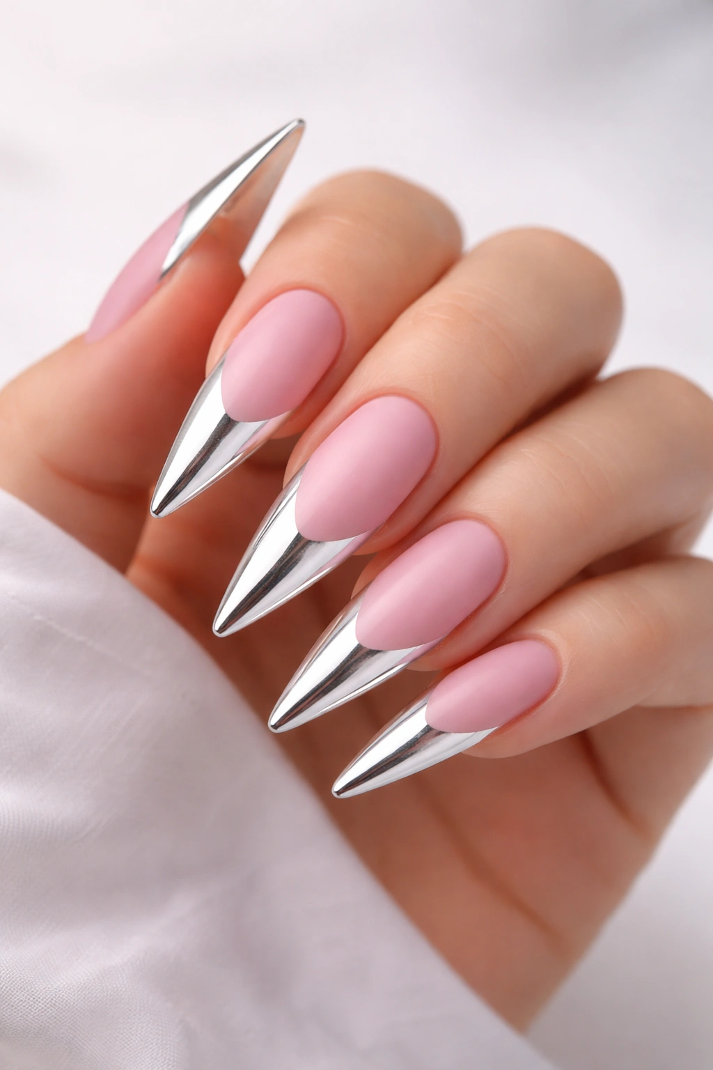 Stiletto nails with chrome mirror tips over a matte pink base