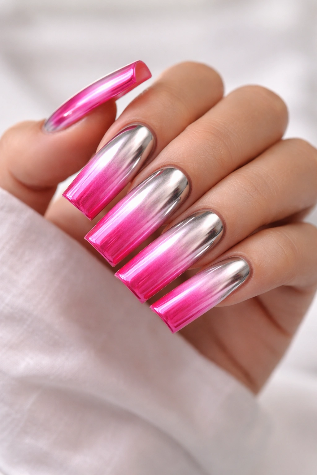 Close-up of hot pink duck nails with chrome reverse ombre from base to tip