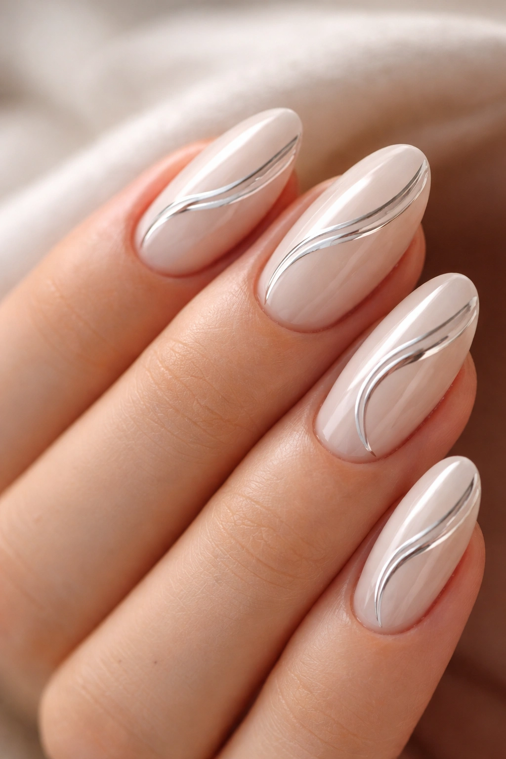 Close-up of short almond nails with chrome swirl on oat milk base
