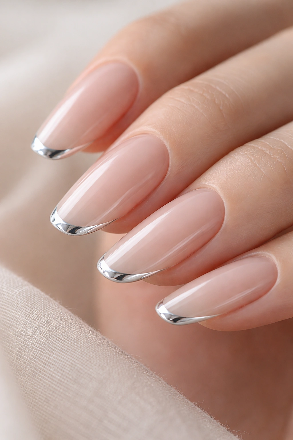 Nude nails with a thin chrome tip along the free edge