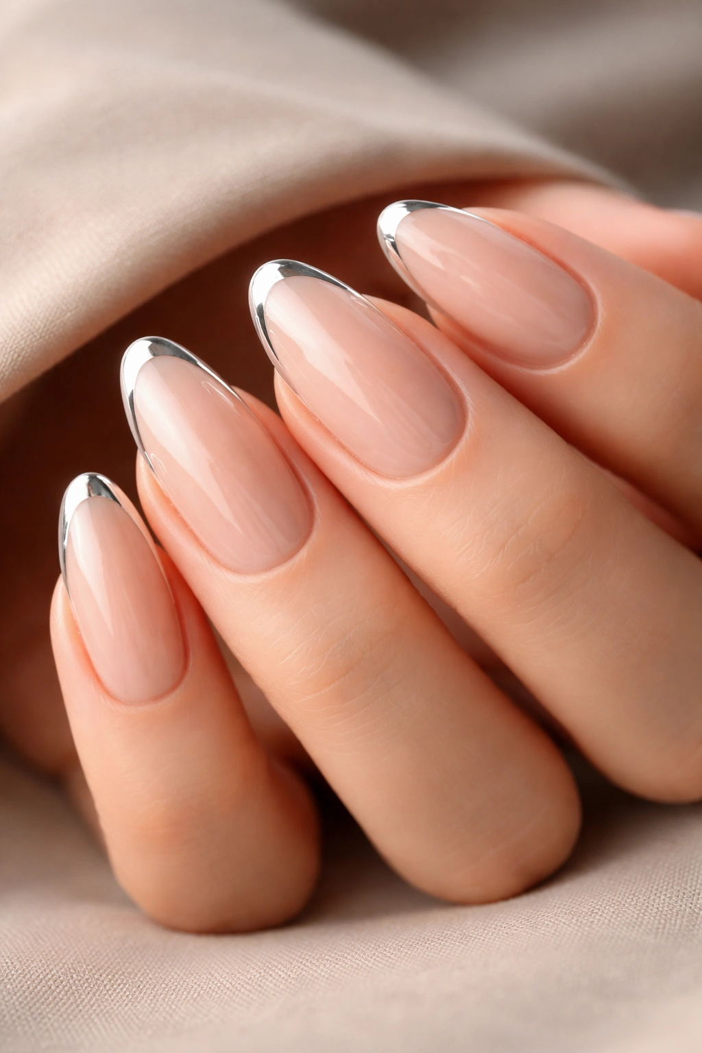 Close-up of long oval nails with chrome tips on nude base
