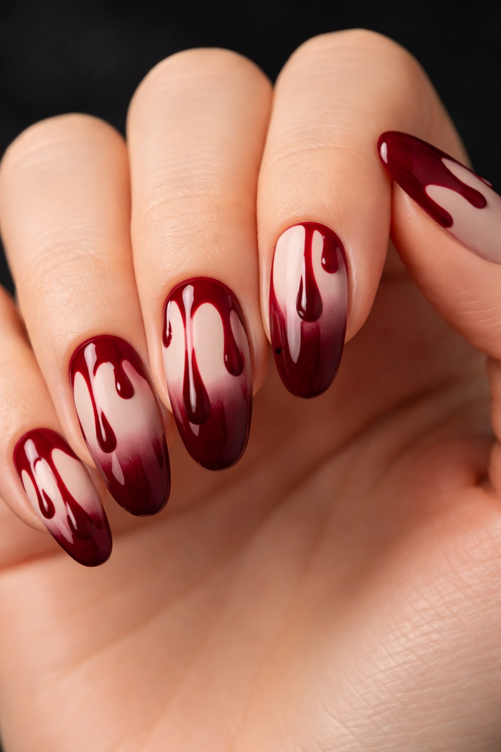 Close-up of classic blood drip nails with burgundy drips on a matte nude base.
