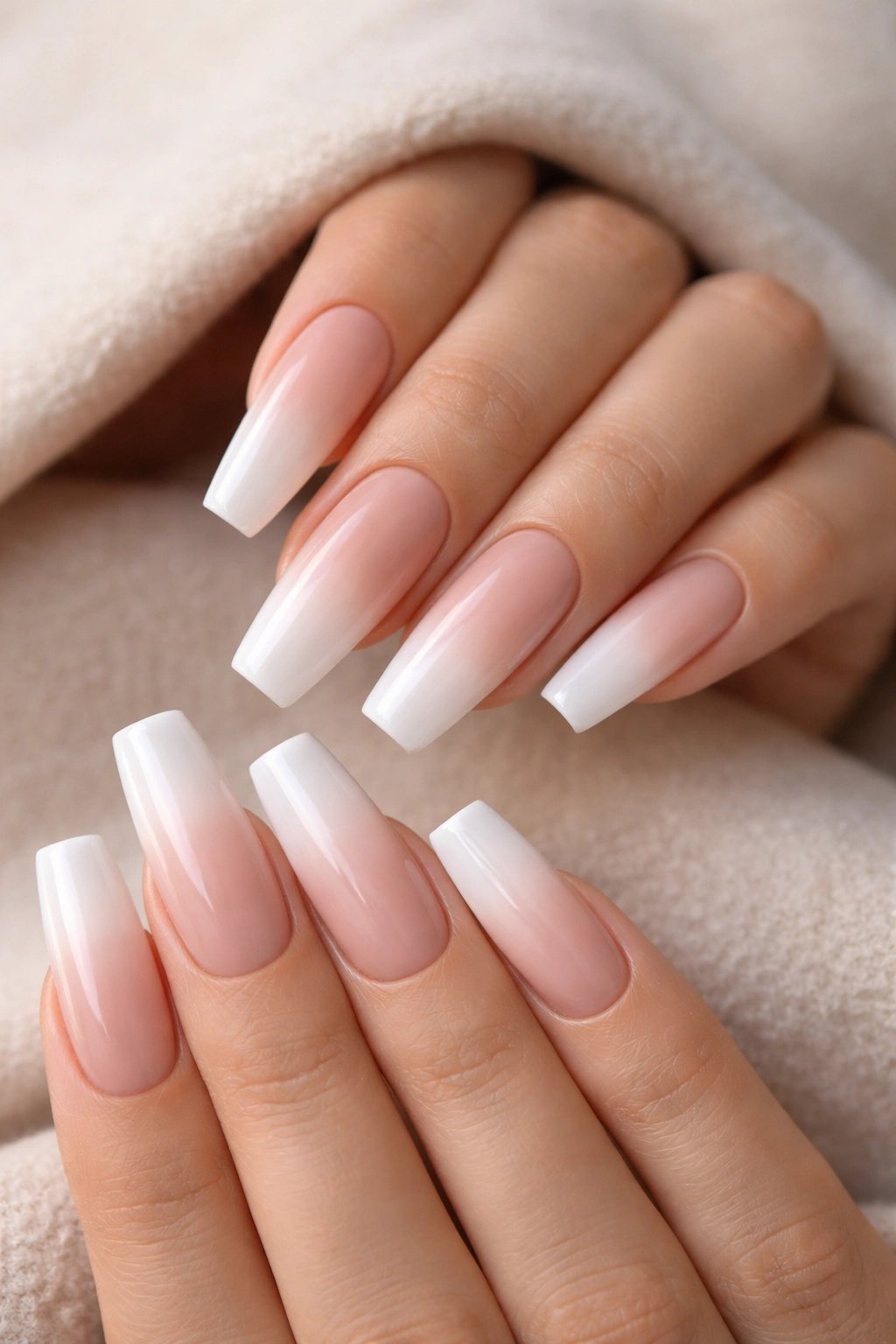 Close-up of coffin nails featuring beige-to-white ombre on nude base