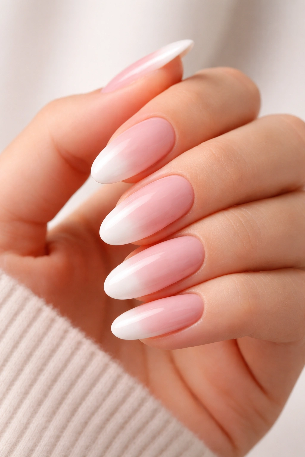 Close-up of long oval nails with a classic French ombre gradient from natural base to white tips
