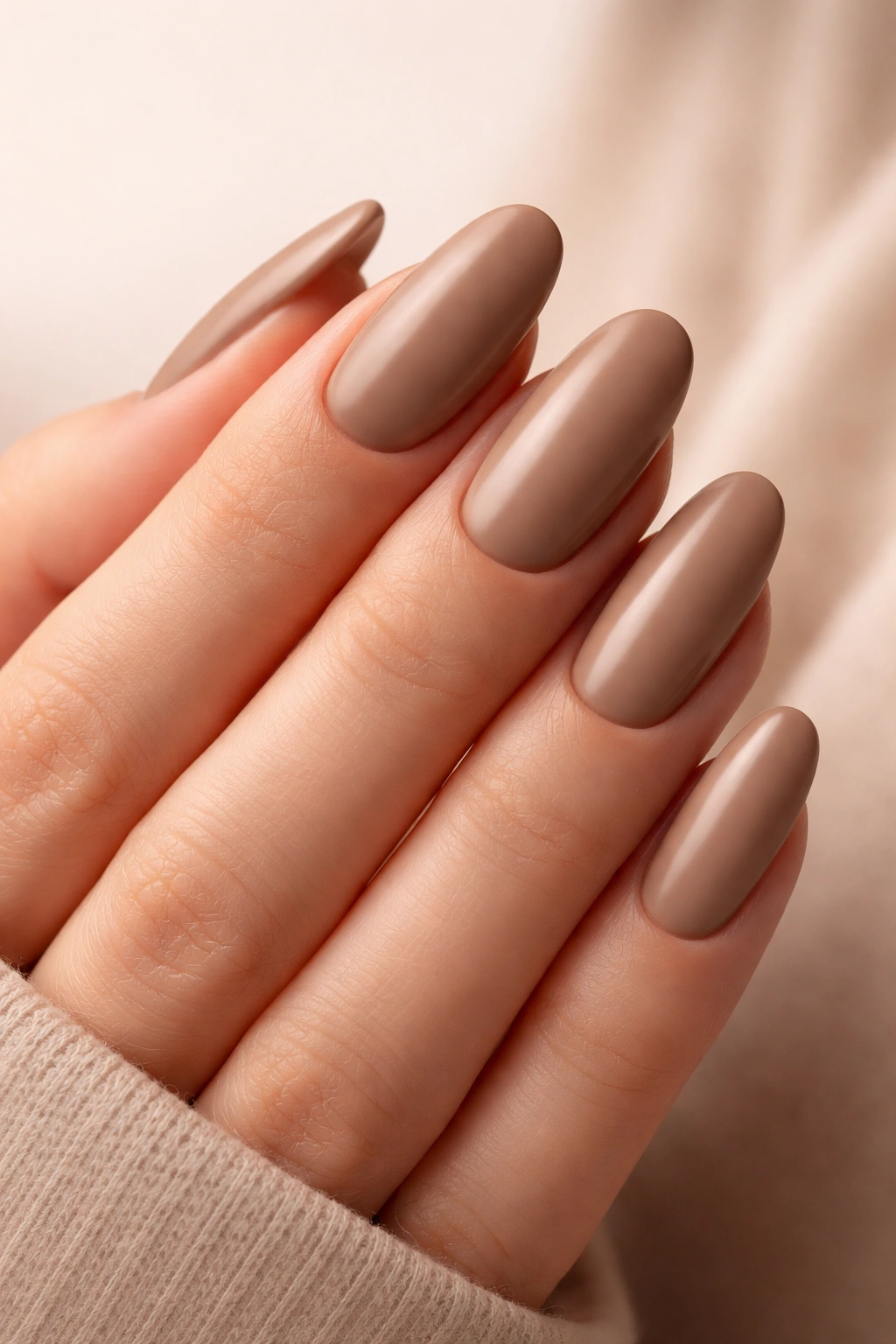 Close-up of long oval nails in classic mocha cream