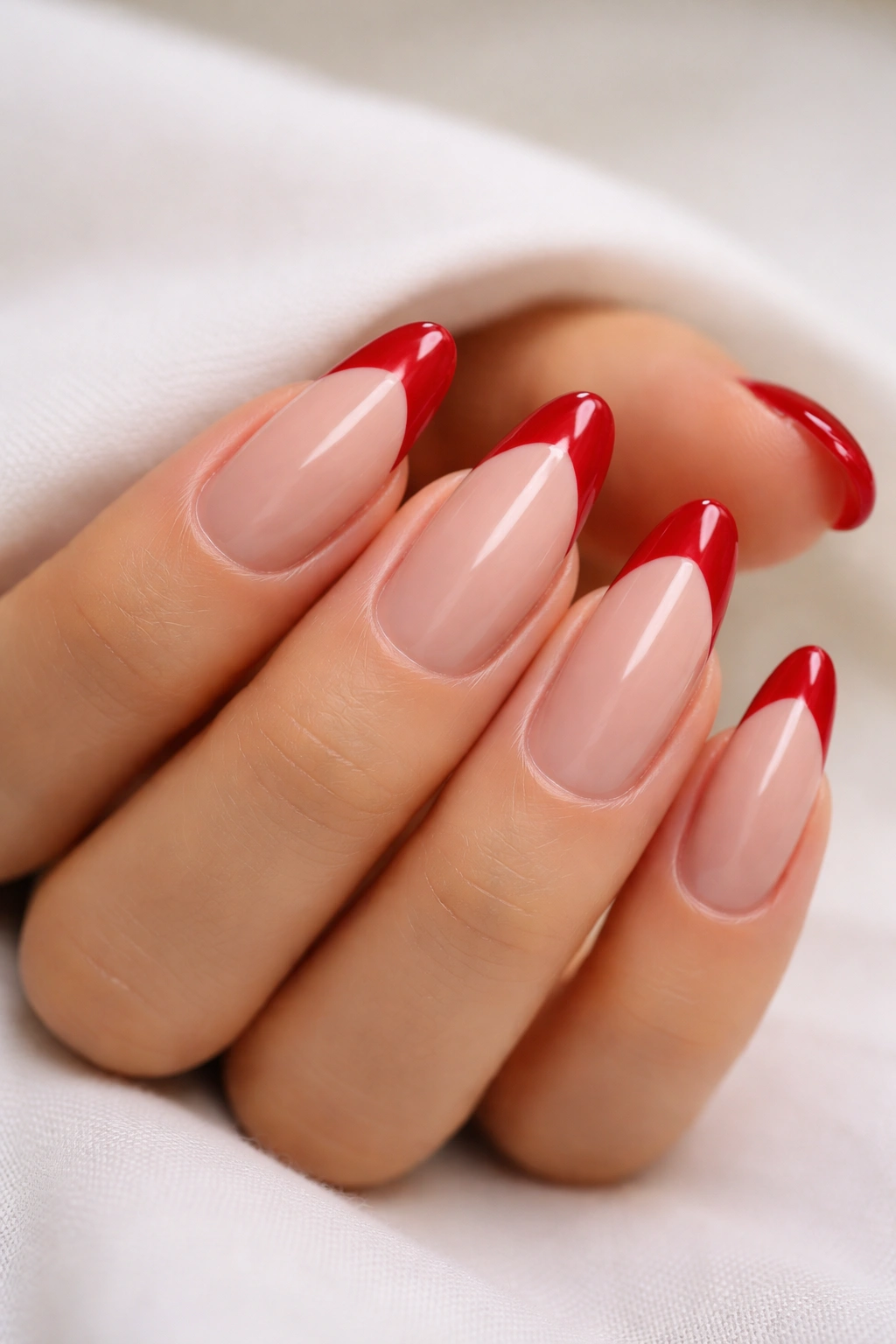 Almond nails with classic red French tips and high-gloss finish