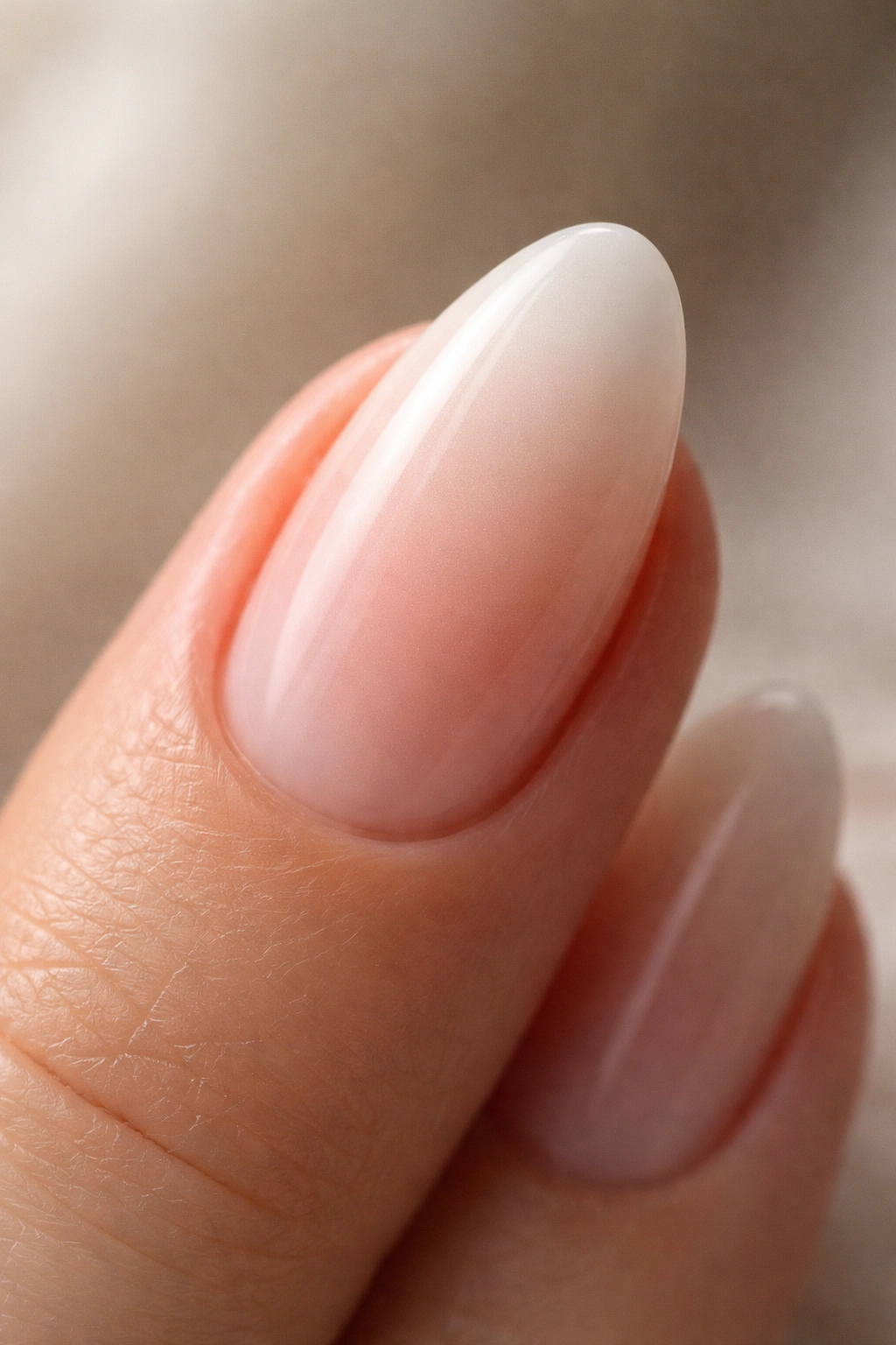 Close-up of a clean, seamless dip powder ombre on short almond nail