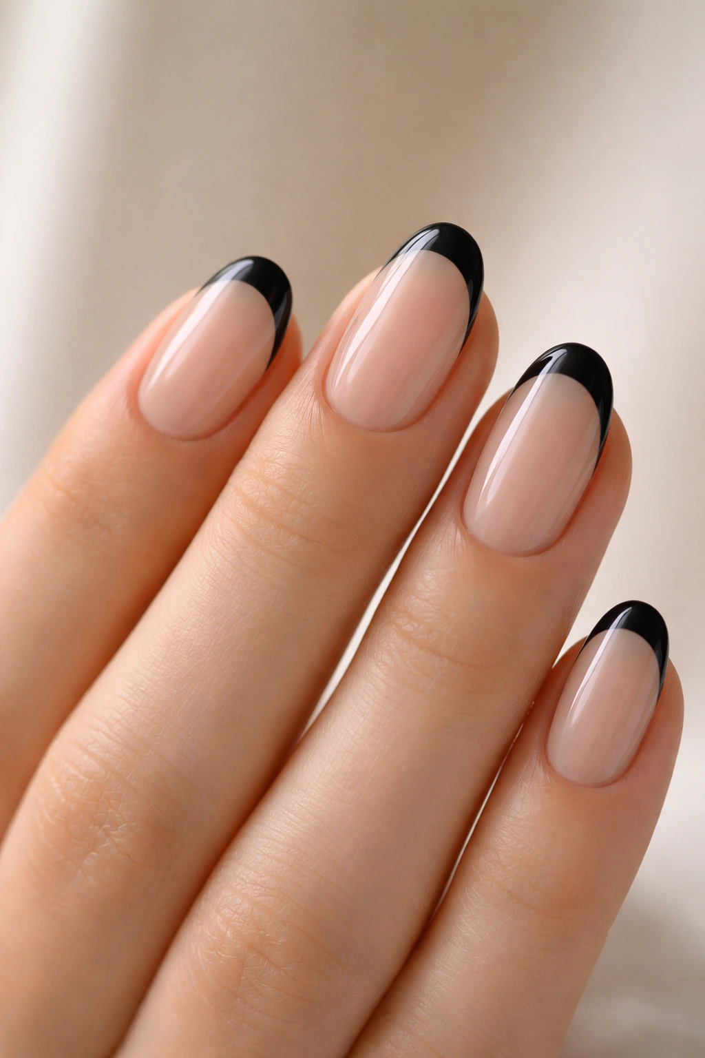 Close-up of short oval nails with clear jelly base and black tips