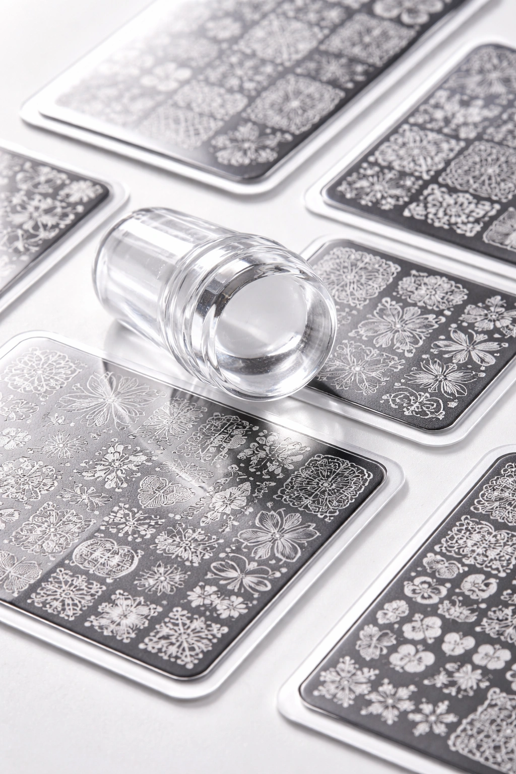 Close-up of clear jelly stamper and etched plates on white surface
