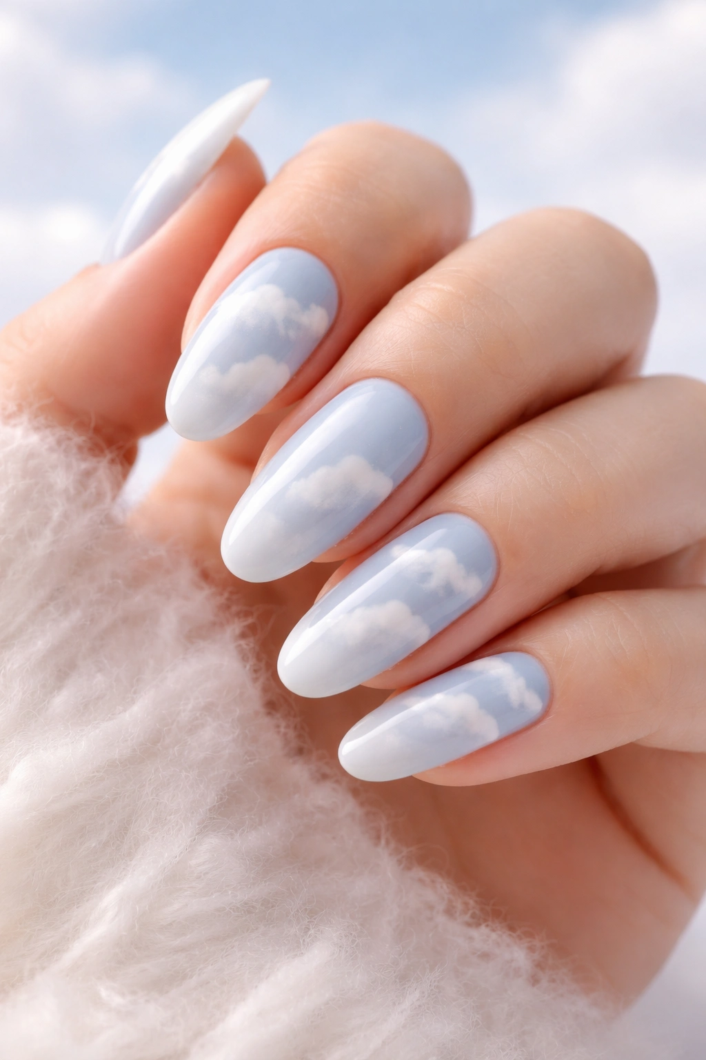 Nails with soft white fluffy cloud designs on pale base