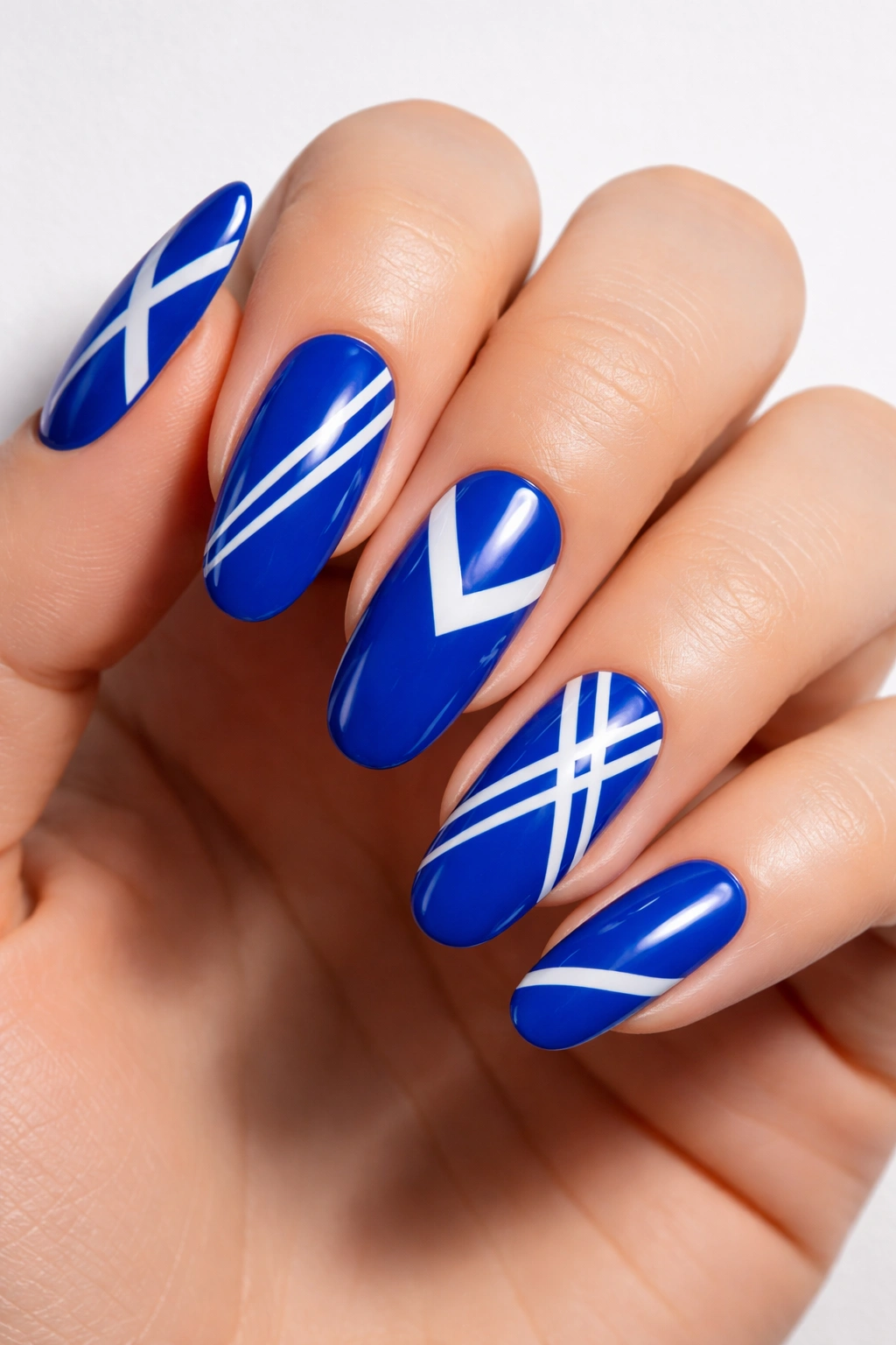 Cobalt blue nails with white geometric patterns close-up