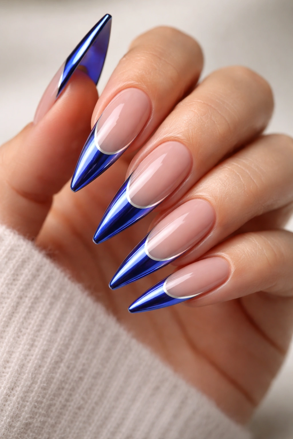 Close-up of cobalt blue French tips with chrome edge on stiletto nails