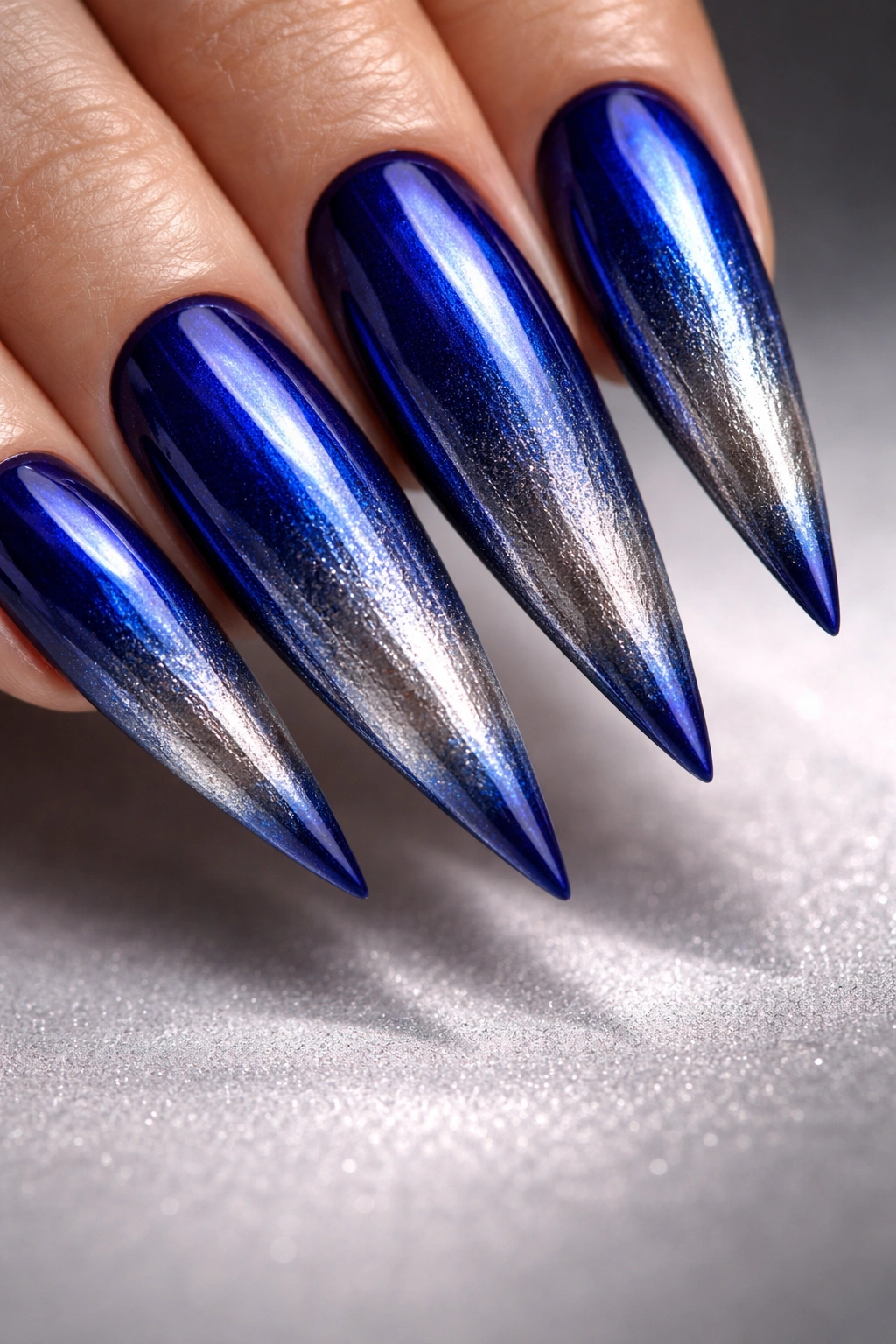 Cobalt blue to metallic gradient on stiletto nails with reflective shine