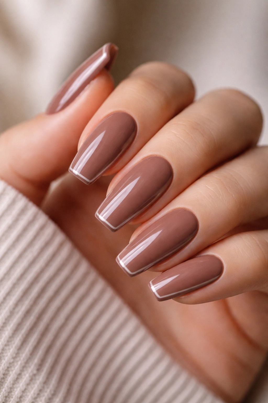 Cocoa nude nails with a thin glossy edge frame on medium-length ballerina nails