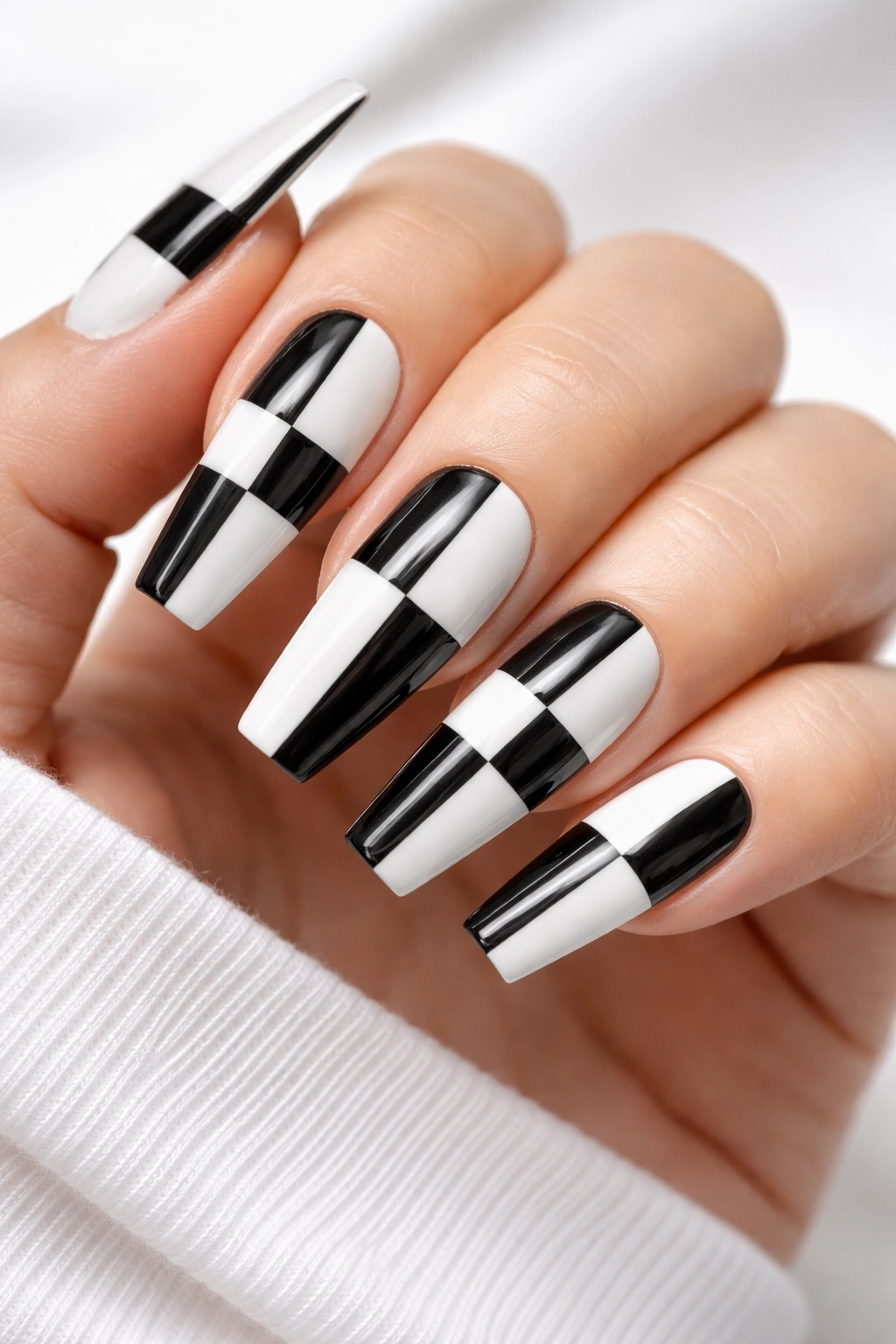 Close-up of coffin nails with geometric black and white block patterns