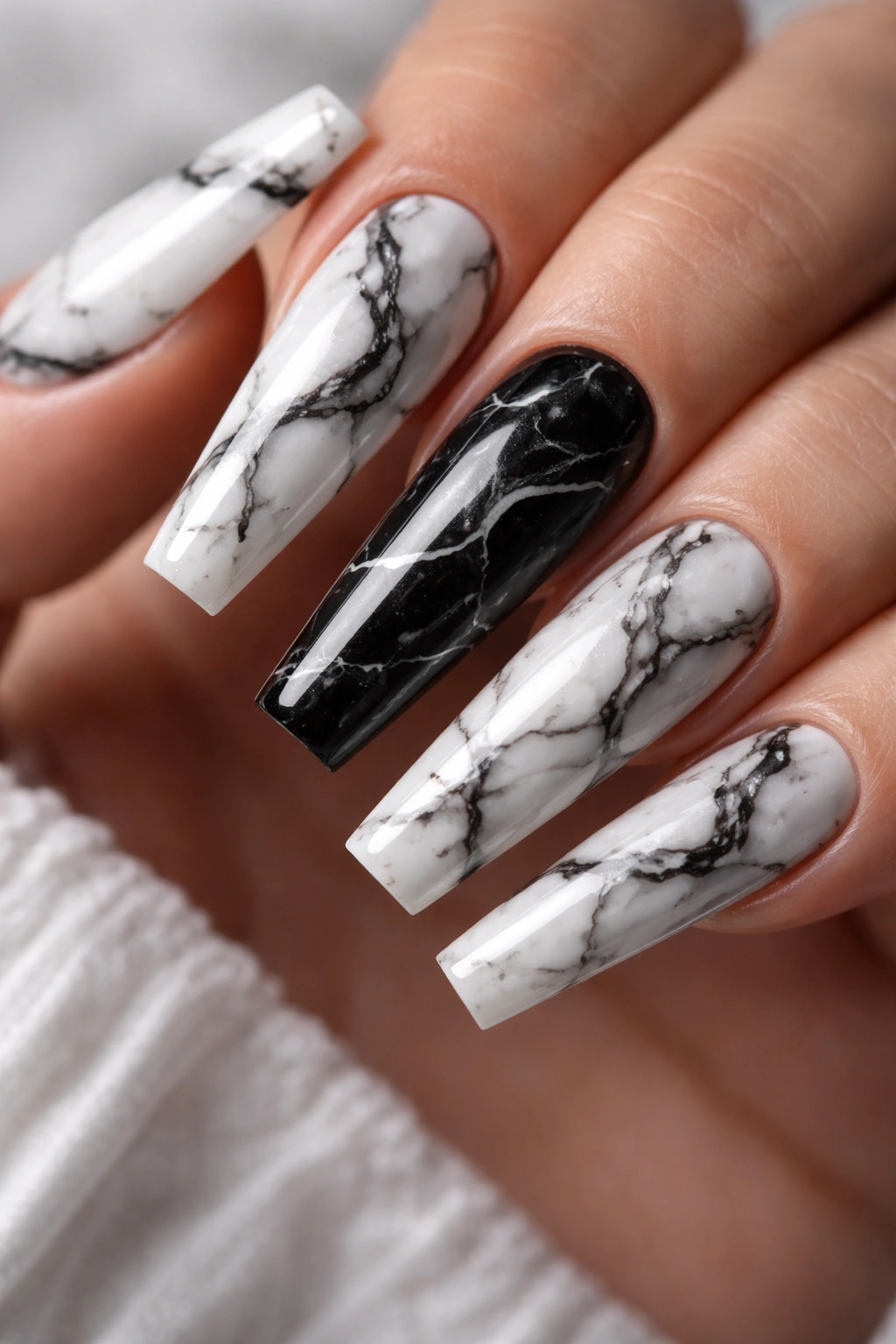 Close-up of marble swirl coffin nails with black veining on white base