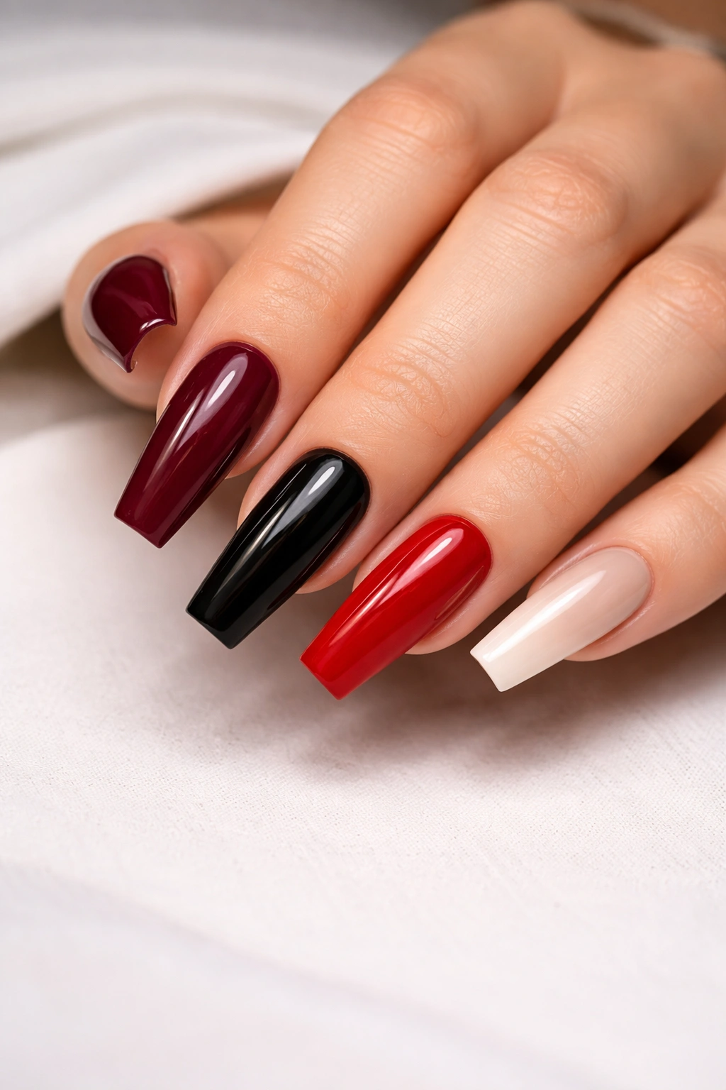 Close-up of coffin-shaped nails in burgundy black and nude tones