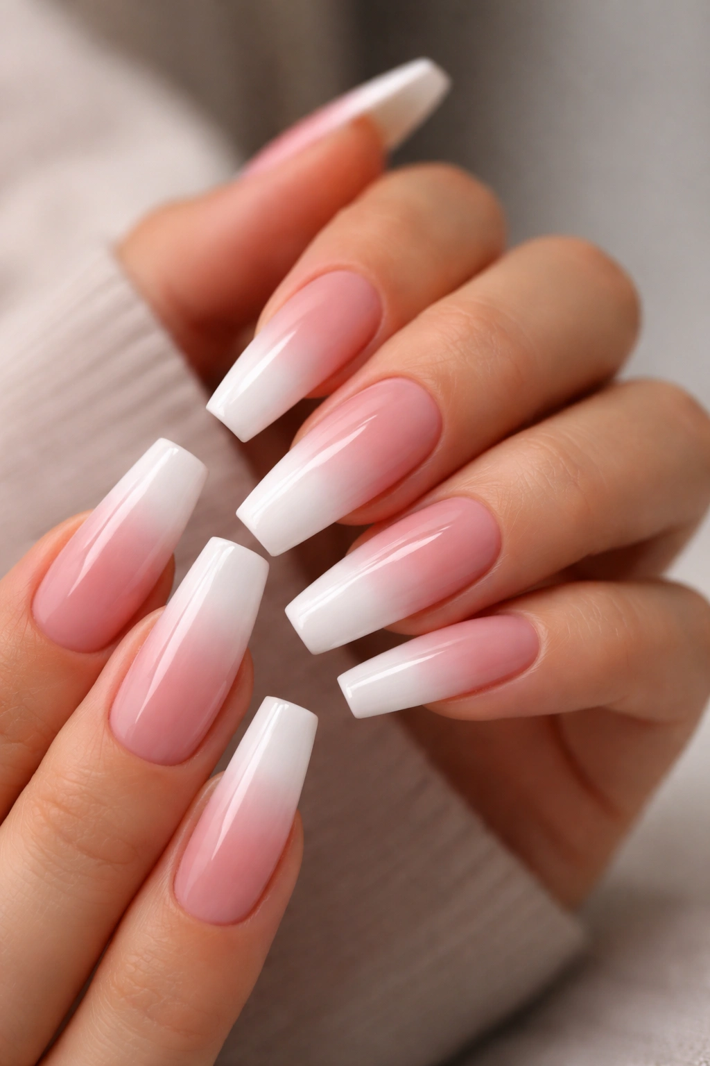 Close-up of long coffin nails with pink-to-white ombré French manicure