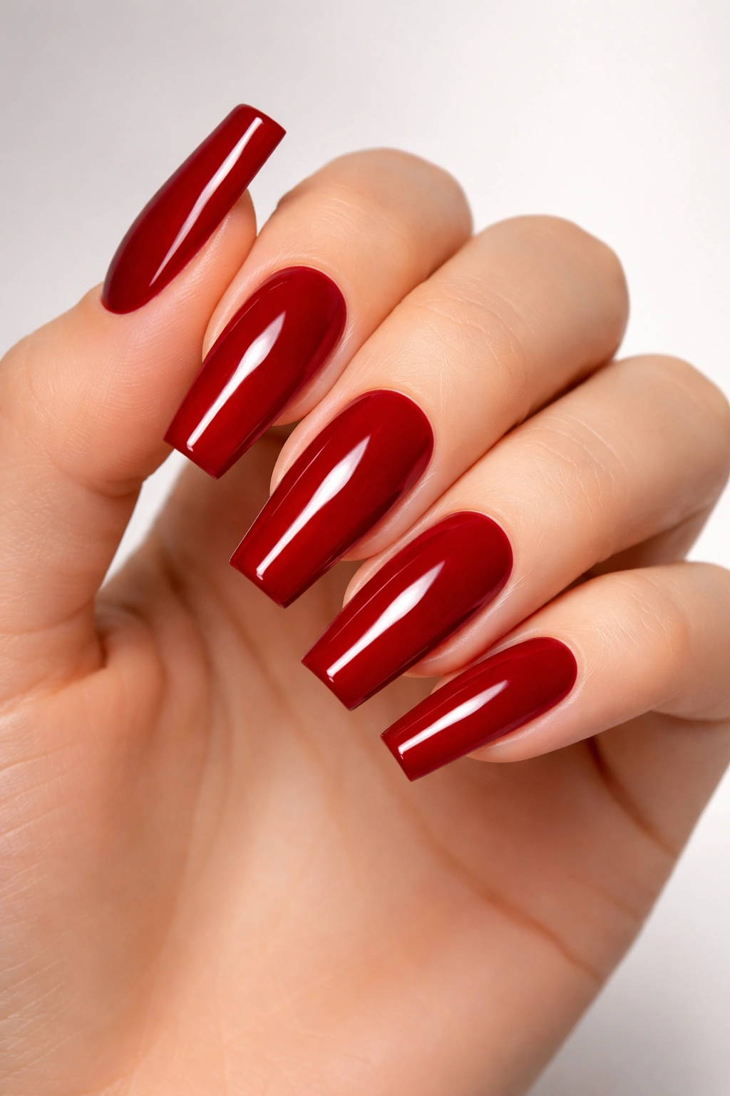 Close-up of coffin nails with squared tips and red polish