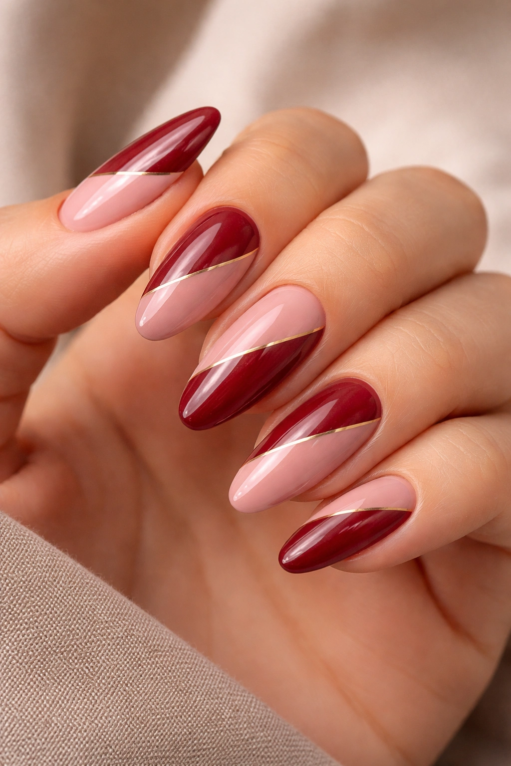 Almond nails with deep red and dusty pink color blocks.