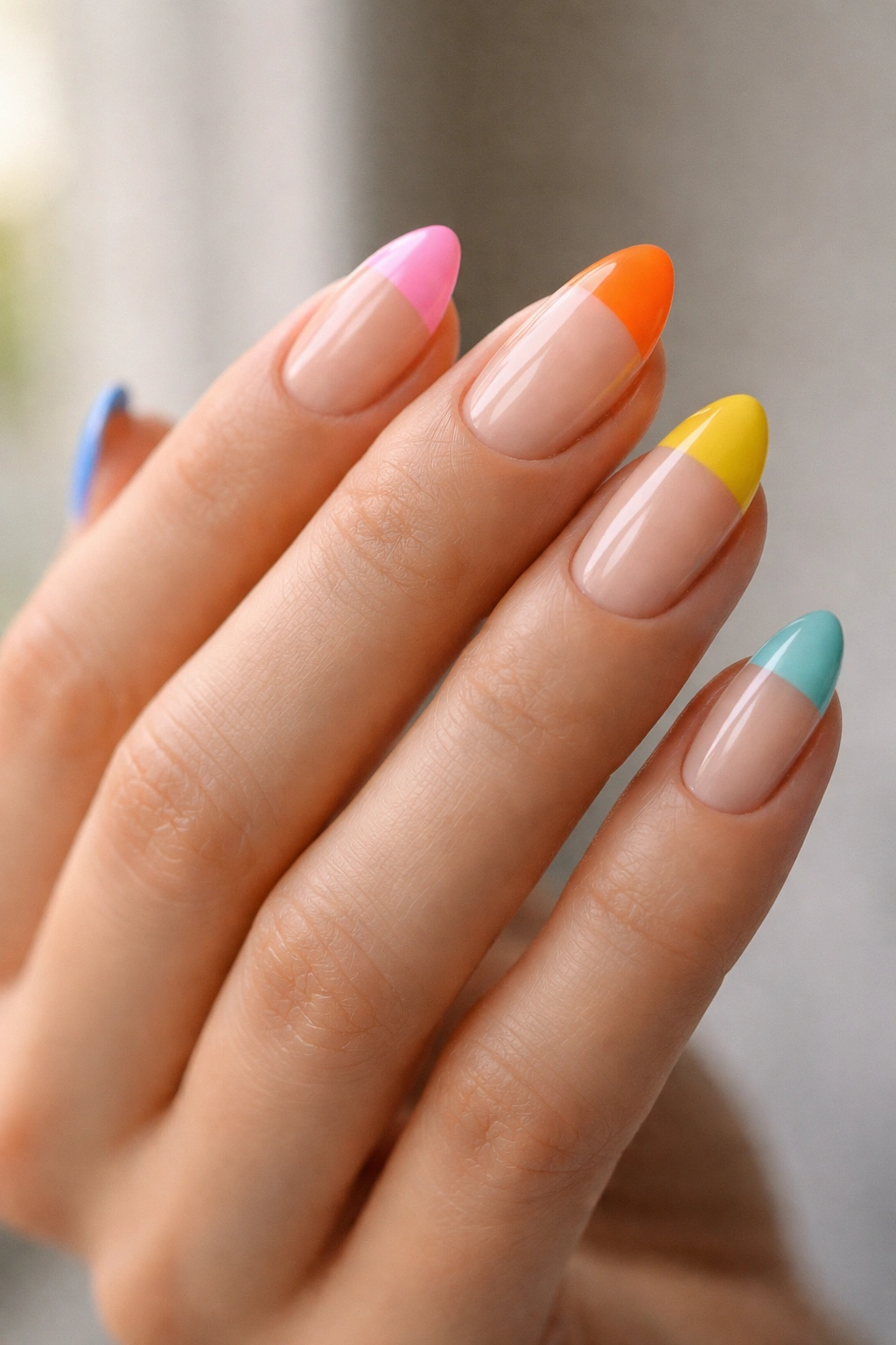 Close-up of short almond nails with color-blocked tips on bare bases.
