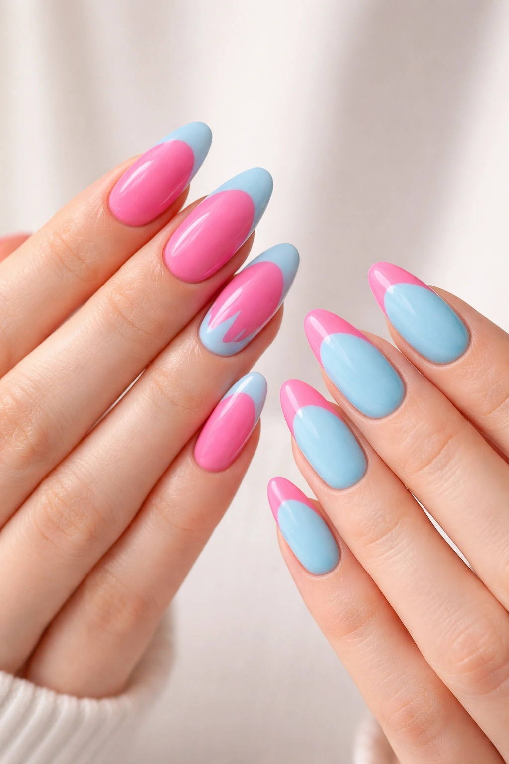 Two hands with opposite color-blocked nails in pink-blue palettes