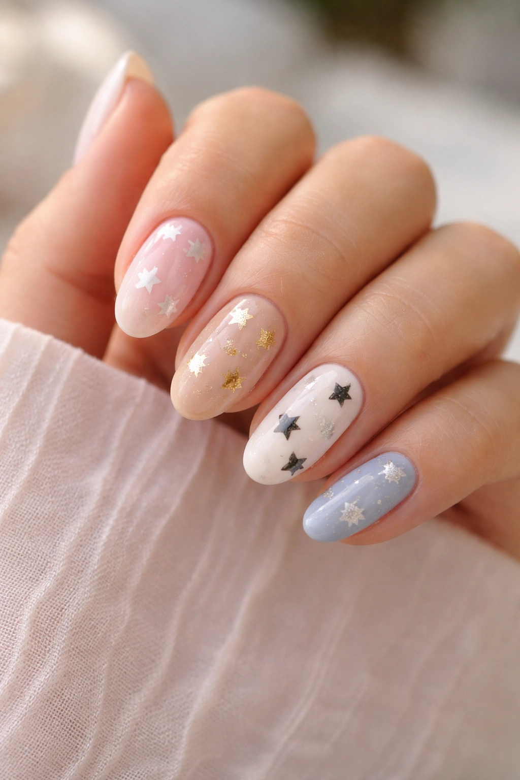 Hand showing color pairings for star nail art on short almond nails