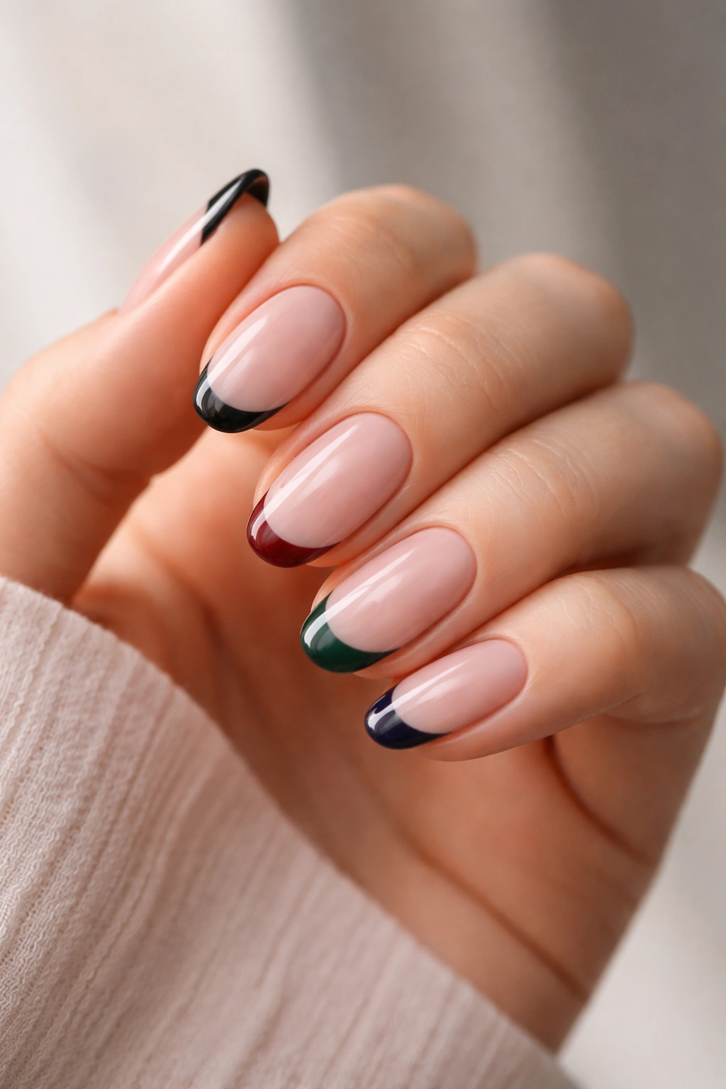 Close-up of short oval nails painted in deep colors to elongate appearance