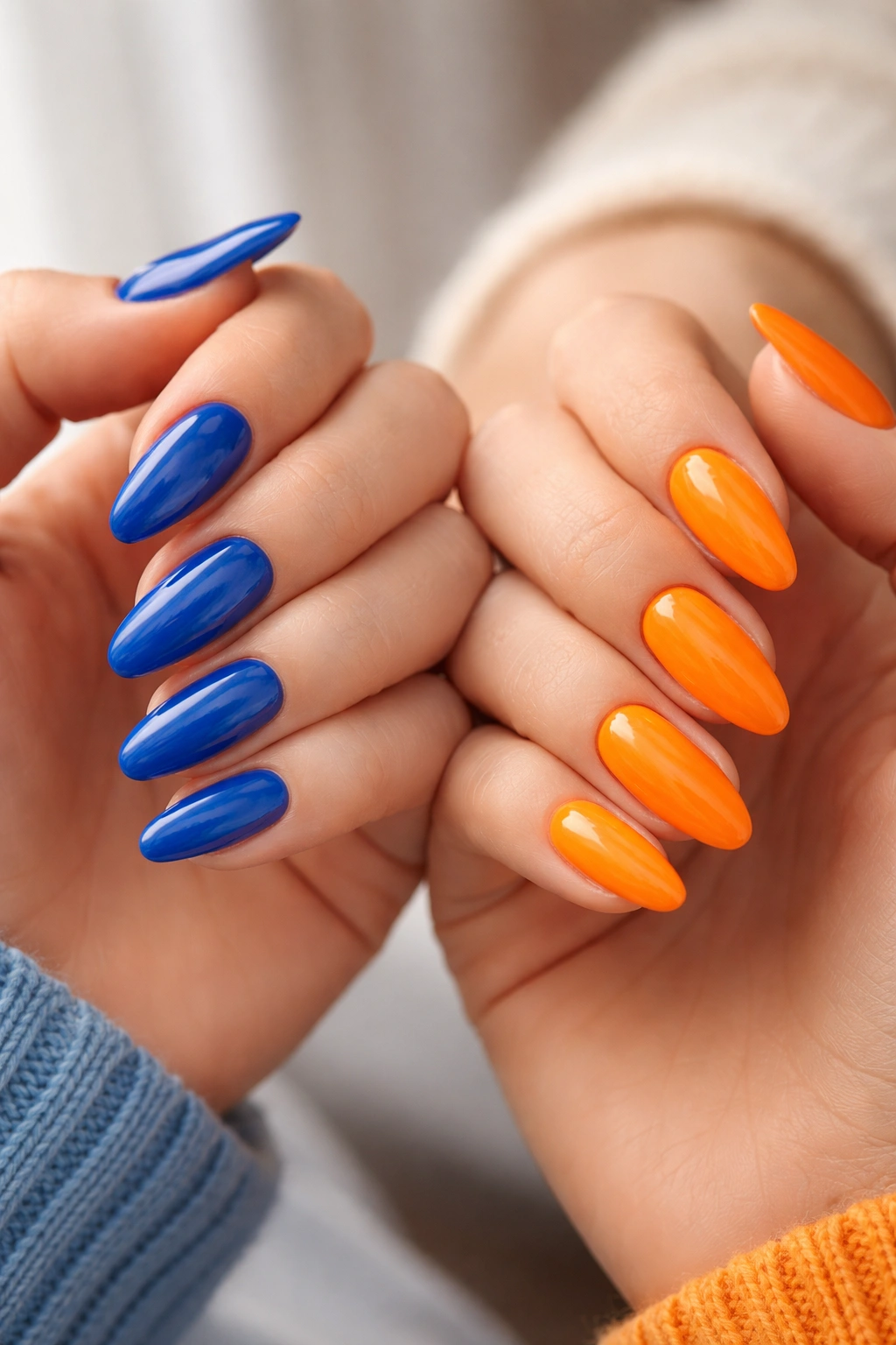 Two hands with blue and orange nails in complementary color pairing