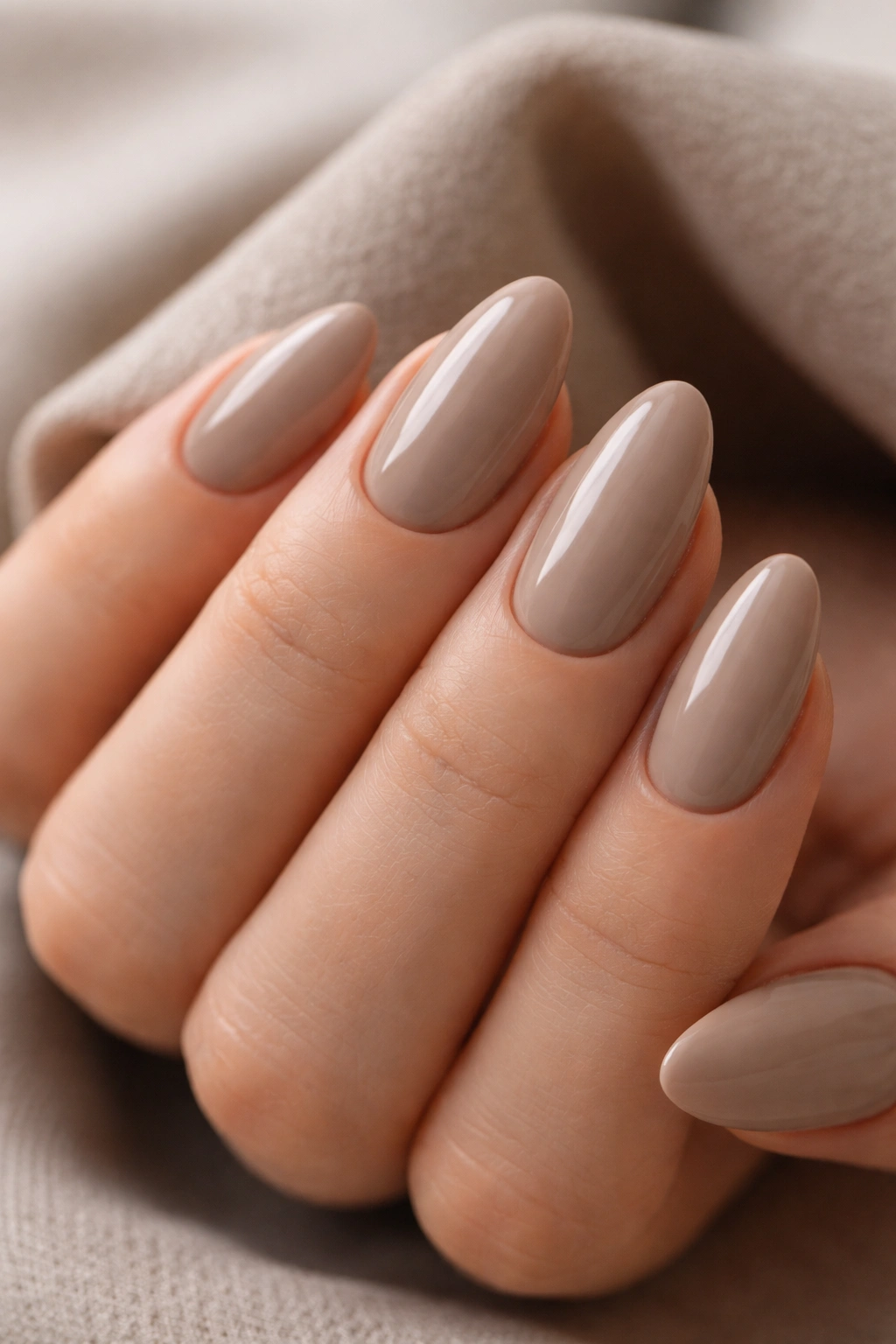 Close-up of cool latte almond nails in muted beige-gray with soft sheen.
