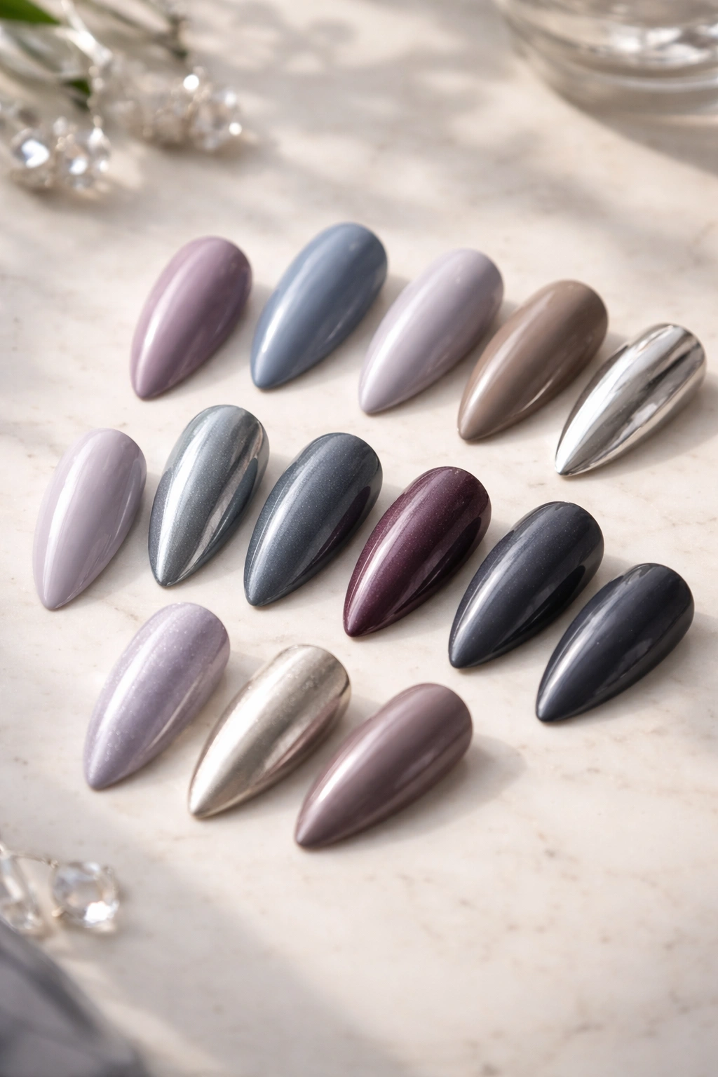 Nail swatches of cool-tone almond shades arranged on a surface