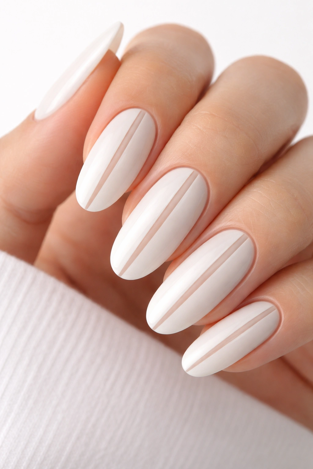Close-up of cool white nails with a vertical negative-space stripe down the center.