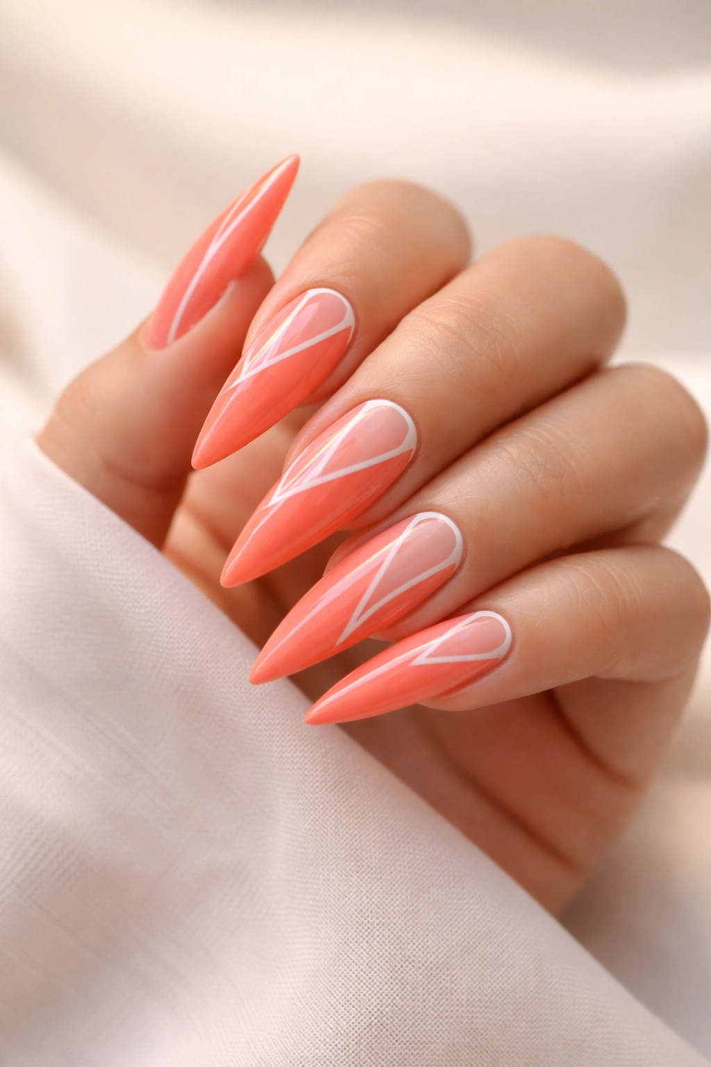 Coral bright stiletto nails with white negative-space patterns
