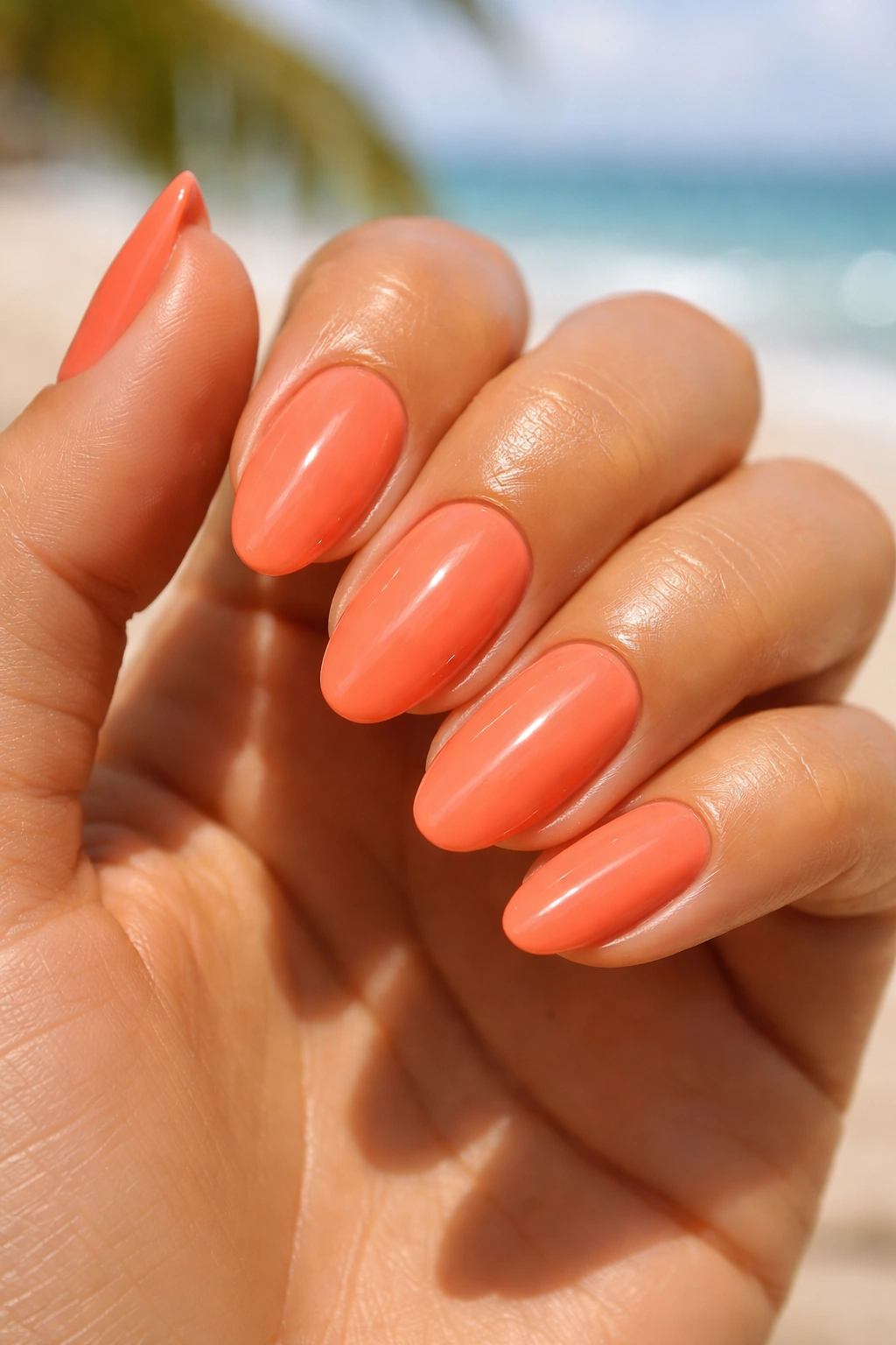Close-up of coral nails on sun-kissed skin