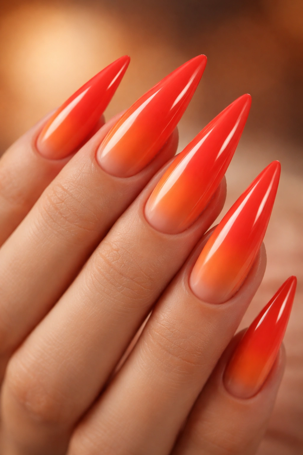 Stiletto nails in coral red to orange ombre gradient