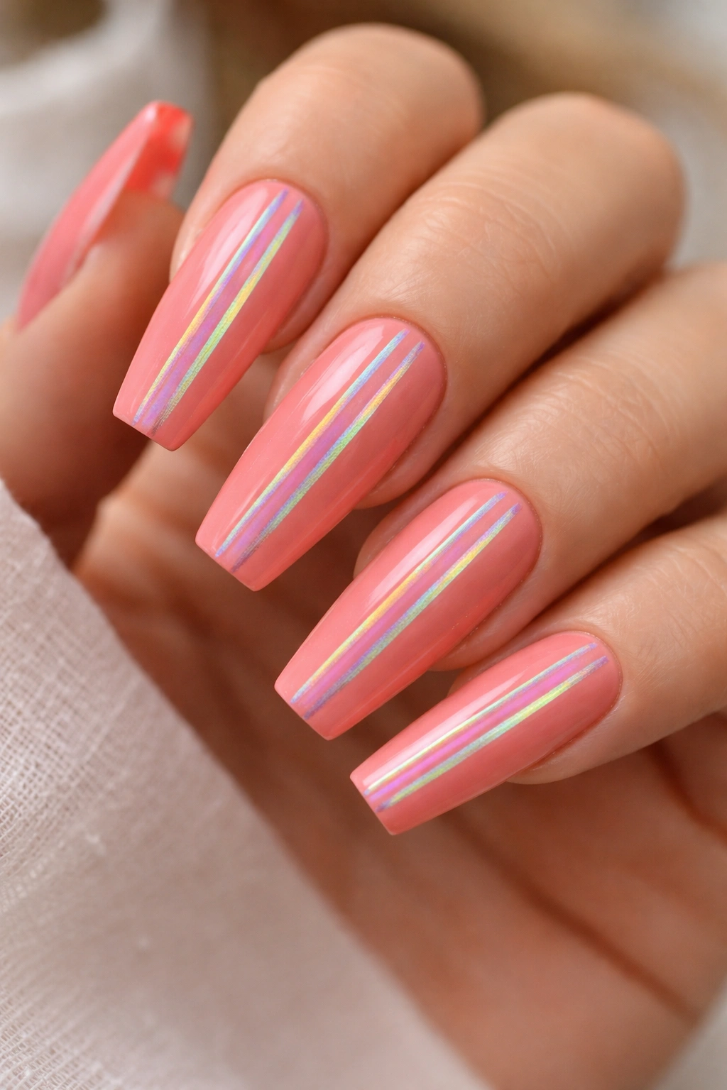Coffin nails in coral pink with holographic vertical stripes.