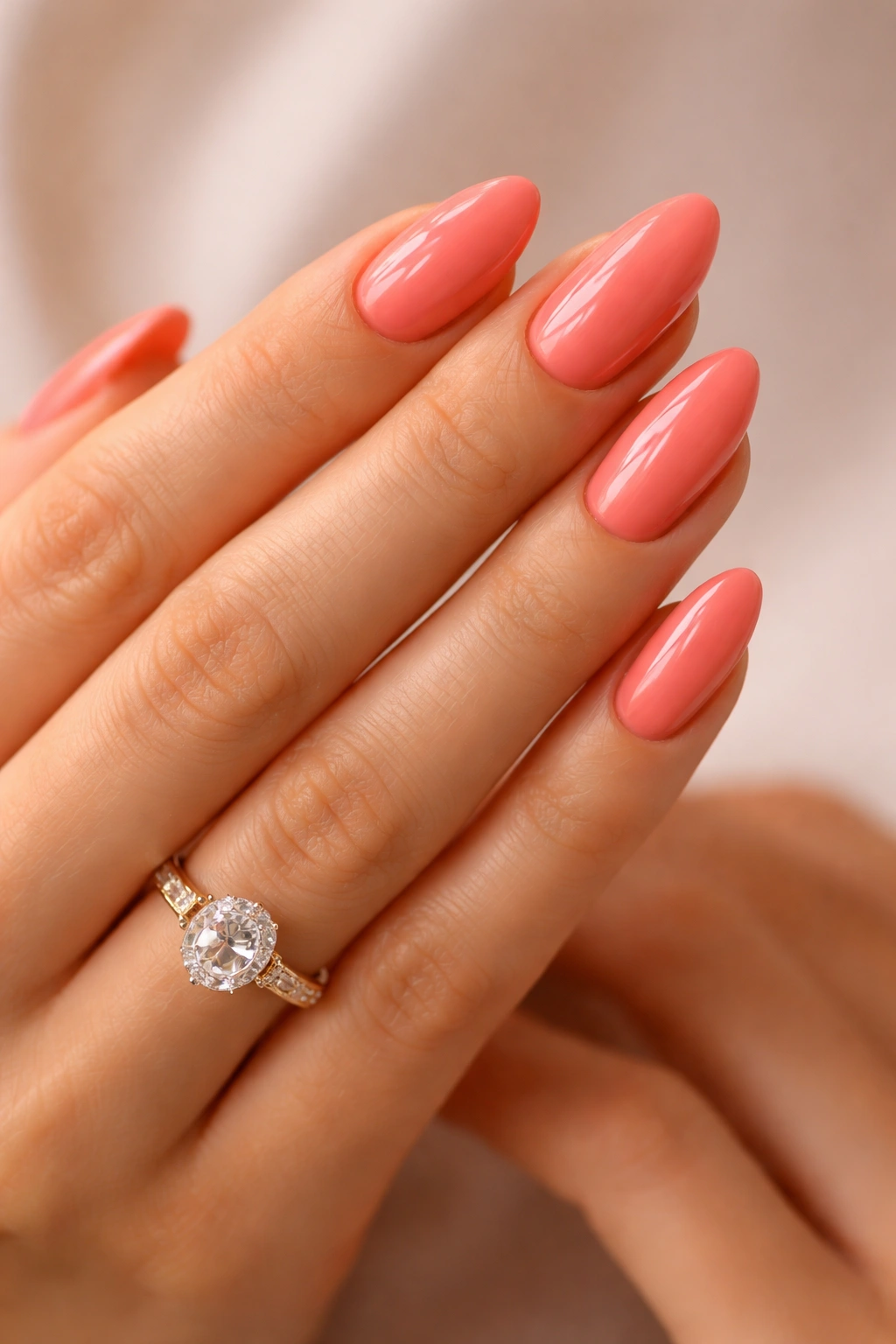Close-up of coral pink nails on hands with soft lighting
