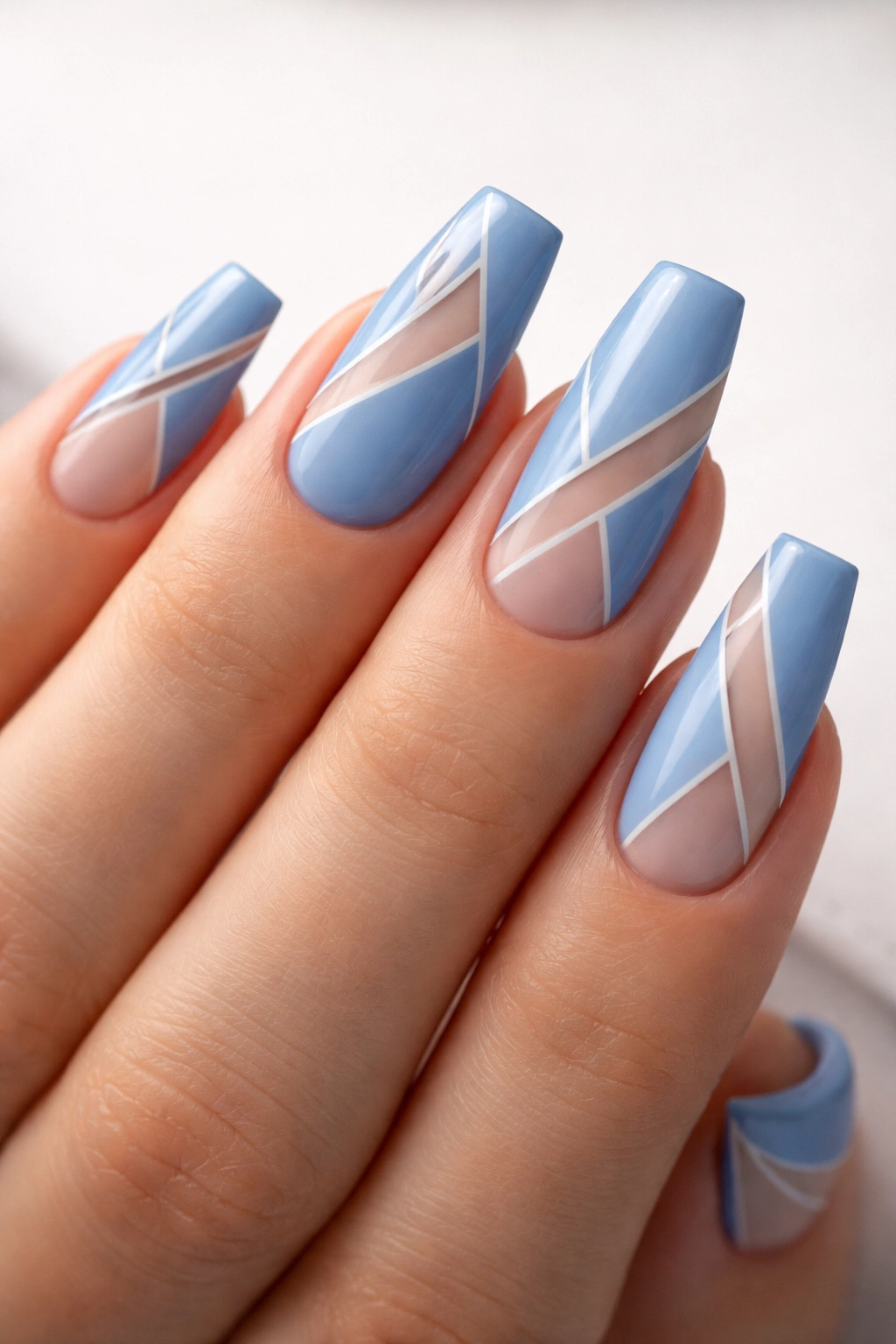 Cornflower blue nails with negative-space geometric patterns.