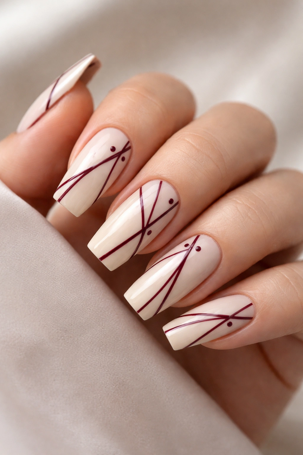 Medium coffin nails with cream base, burgundy geometric lines and dots