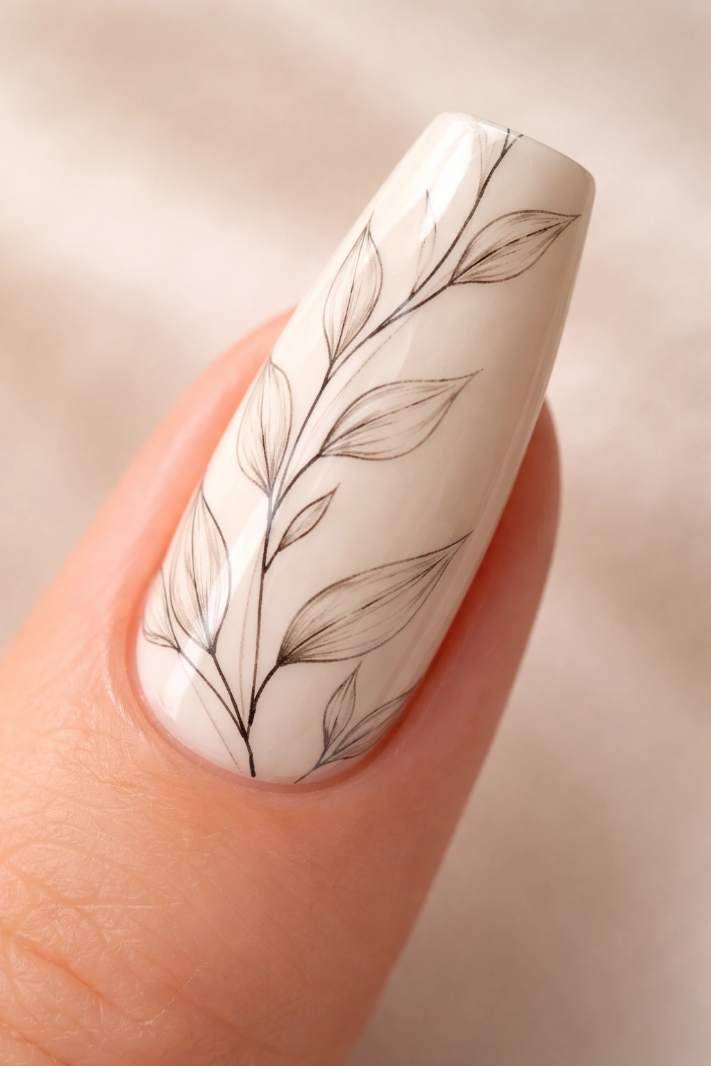 Close-up of cream coffin nail with hand-drawn botanical line sketch