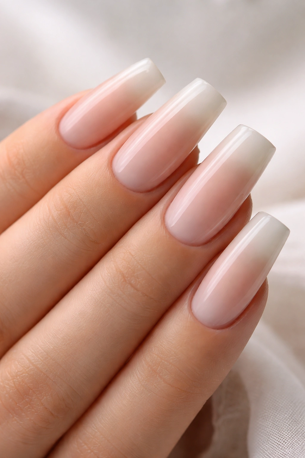 Close-up of medium duck nails with creamy French ombré gradient from cream to sheer tip