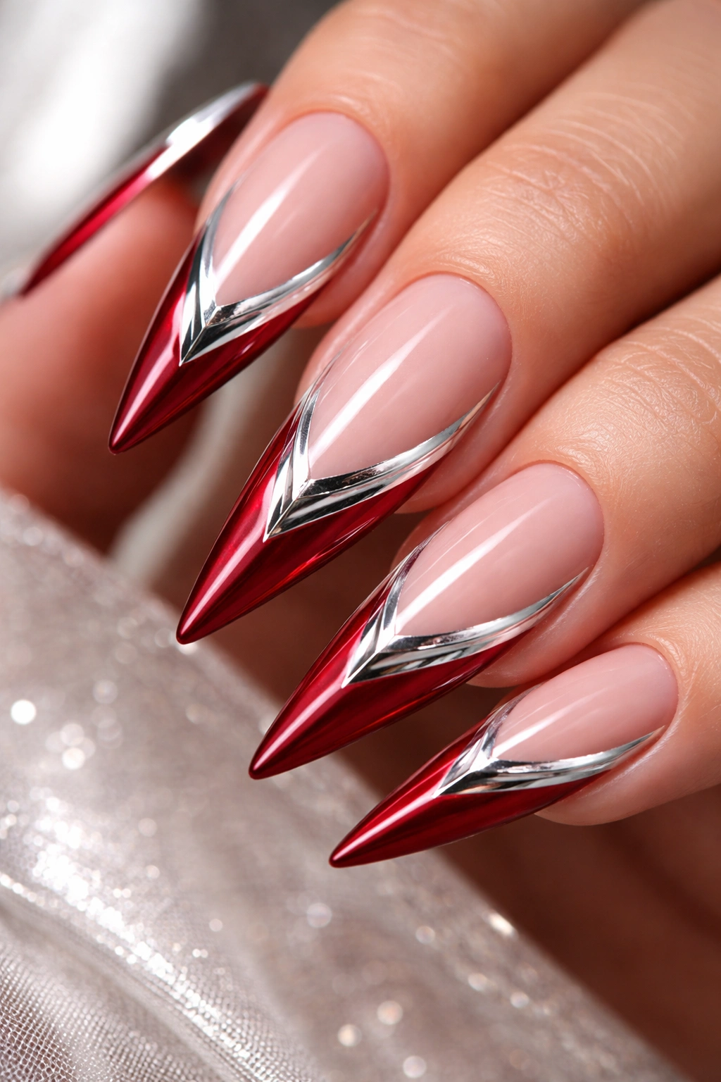 Crimson stiletto nails with white tips and chrome accents.