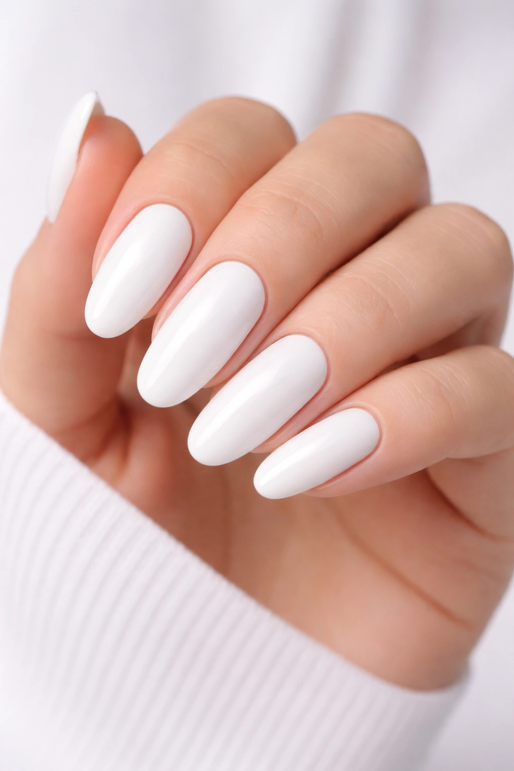 Close-up of long oval nails in crisp white with a glossy finish